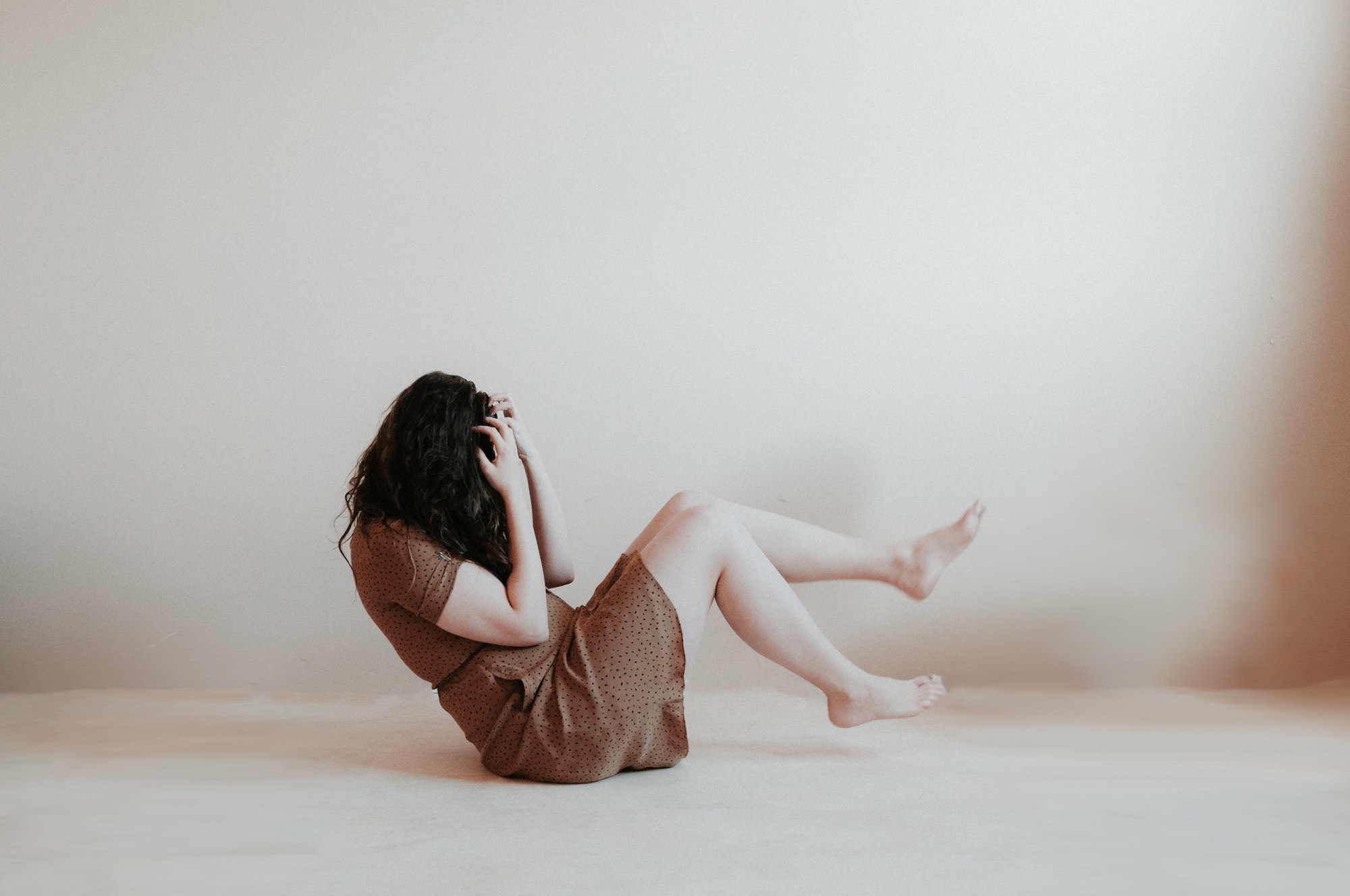 woman lying on floor holding head