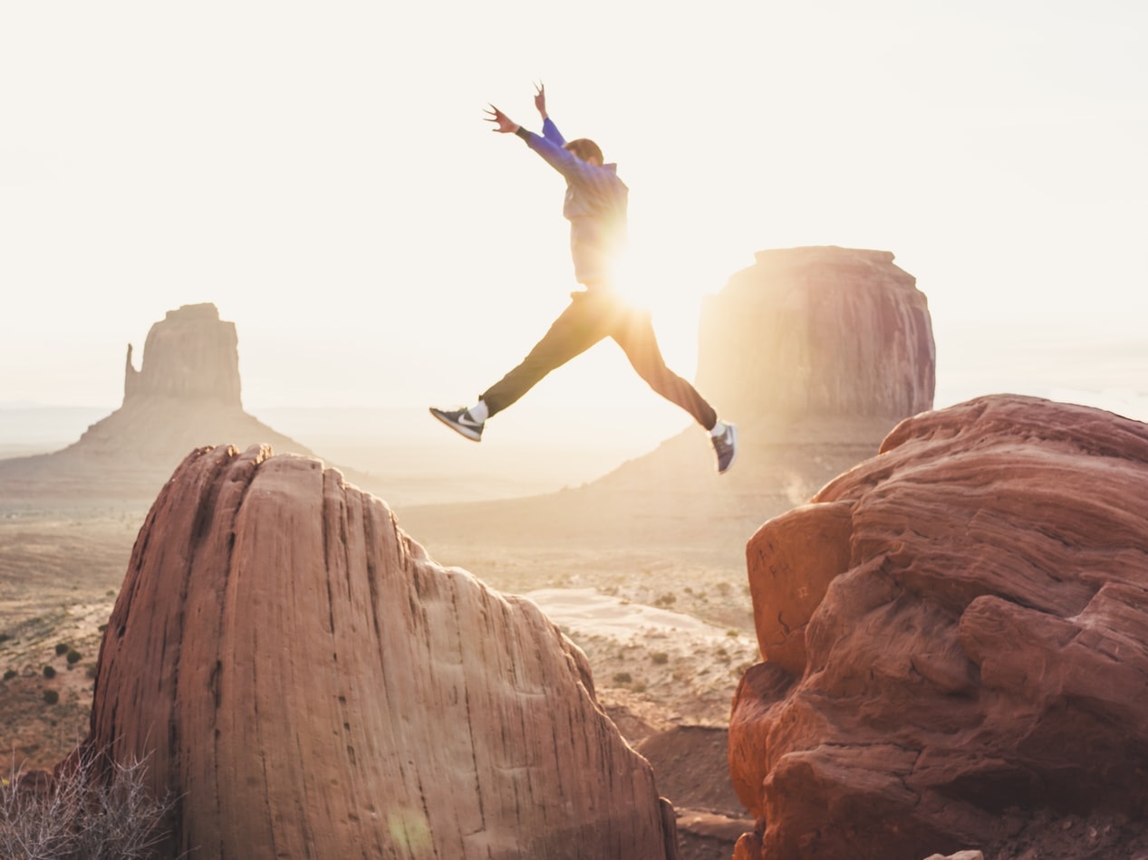 man jumping from rock to rock