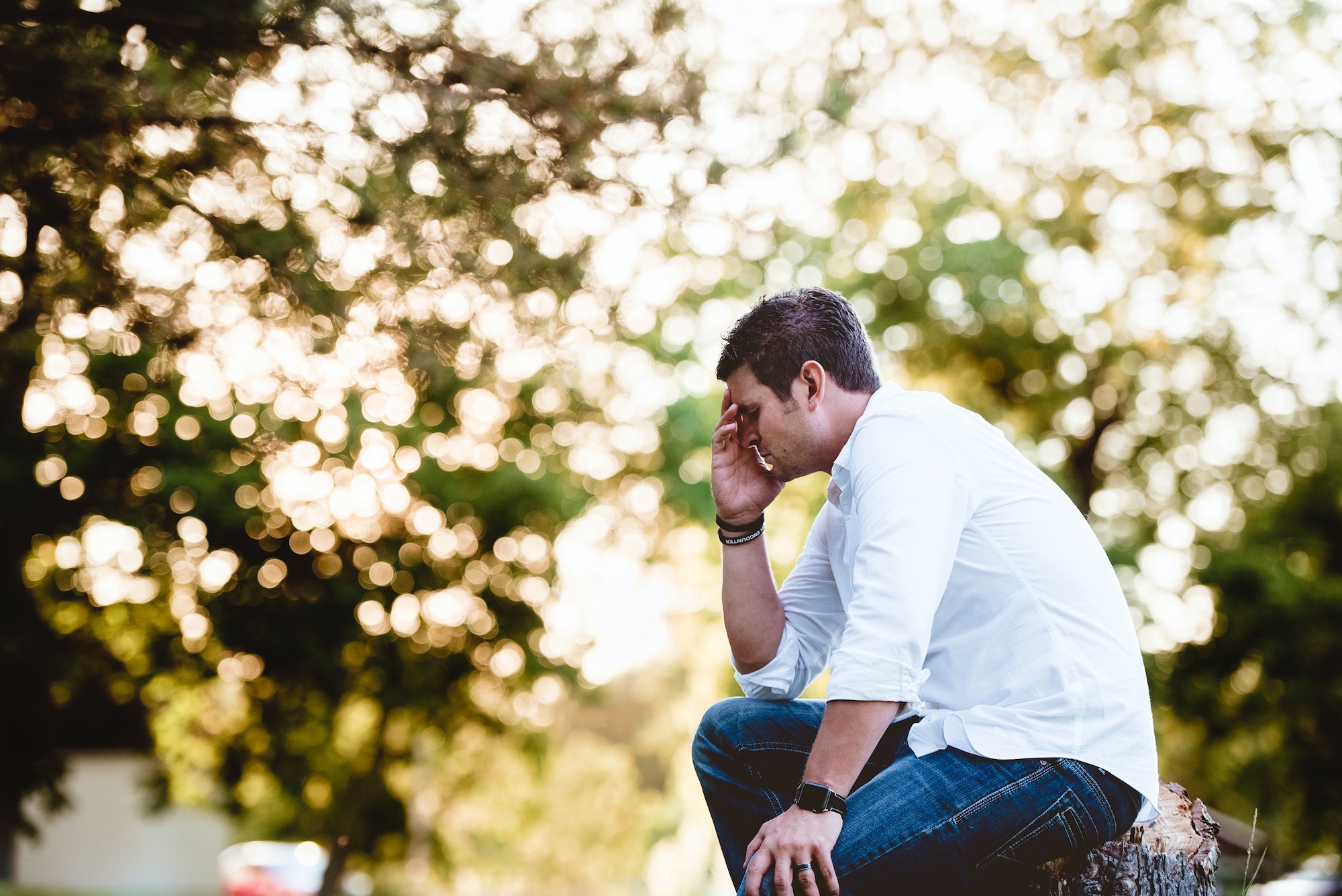 man sitting down holding head